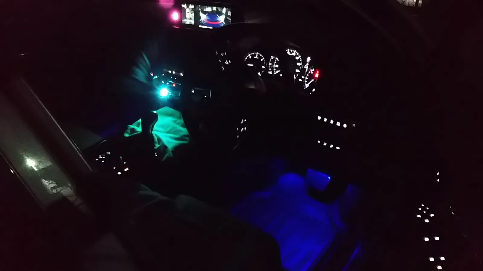 これも有名な話ですが，CX-30はコンソールまわりの照明がなく、真っ暗闇なんです．
そこでLEDライトを前部USBに挿し，イルミを足元の奥に取り付けてブルーライトの間接照明風に．USBが少ないので，イルミはコンソールボックス内のシガレットコンセントからケーブルを引き出してます．ケーブルは目障りですが，夜は見えないのでいい感じです．
（ちょっとピンぼけですが雰囲気はわかりますよね）
