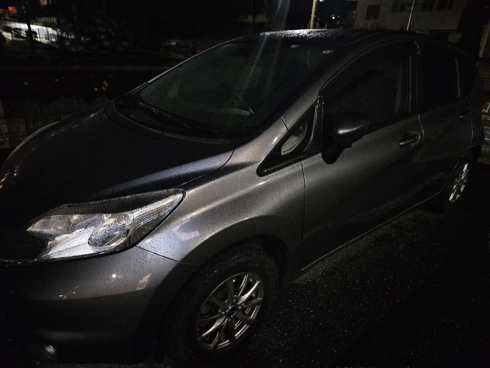 日産ノートE12のガンメタ。
グレードはガソリン車のX。
e-powerはついていません。
前の車のエンジンが壊れてしまい、直すと30万ぐらい掛かるから新しく買った方が良いとディーラーに助言され、かつ車検も迫っていたので急いで探しました。
色が自分好みで走行距離が2.3万程度で状態も良かった為即決。
夜に撮影したので見にくいかも知れませんが、ドノーマルです。
新型ノートが発表されたので型落ちノートが安く購入出来る様です。
ウチの車はもう2代前になっちゃったのか。
タイヤはスタッドレスでアルミホイール。
185/70r14で純正サイズ。
まだ購入したばかりで新しいです。