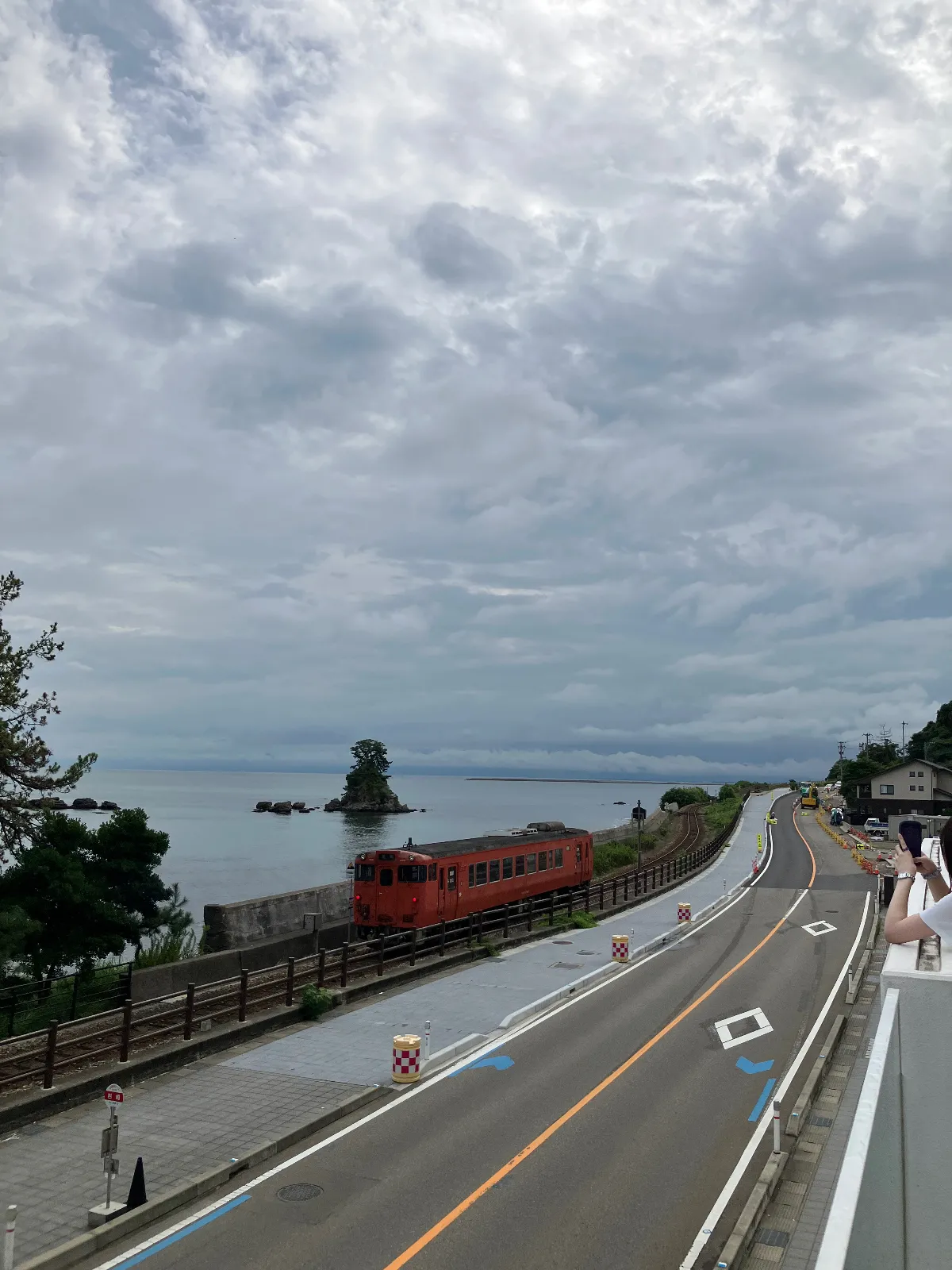 義経岩と曇りの立山連峰。　と電車