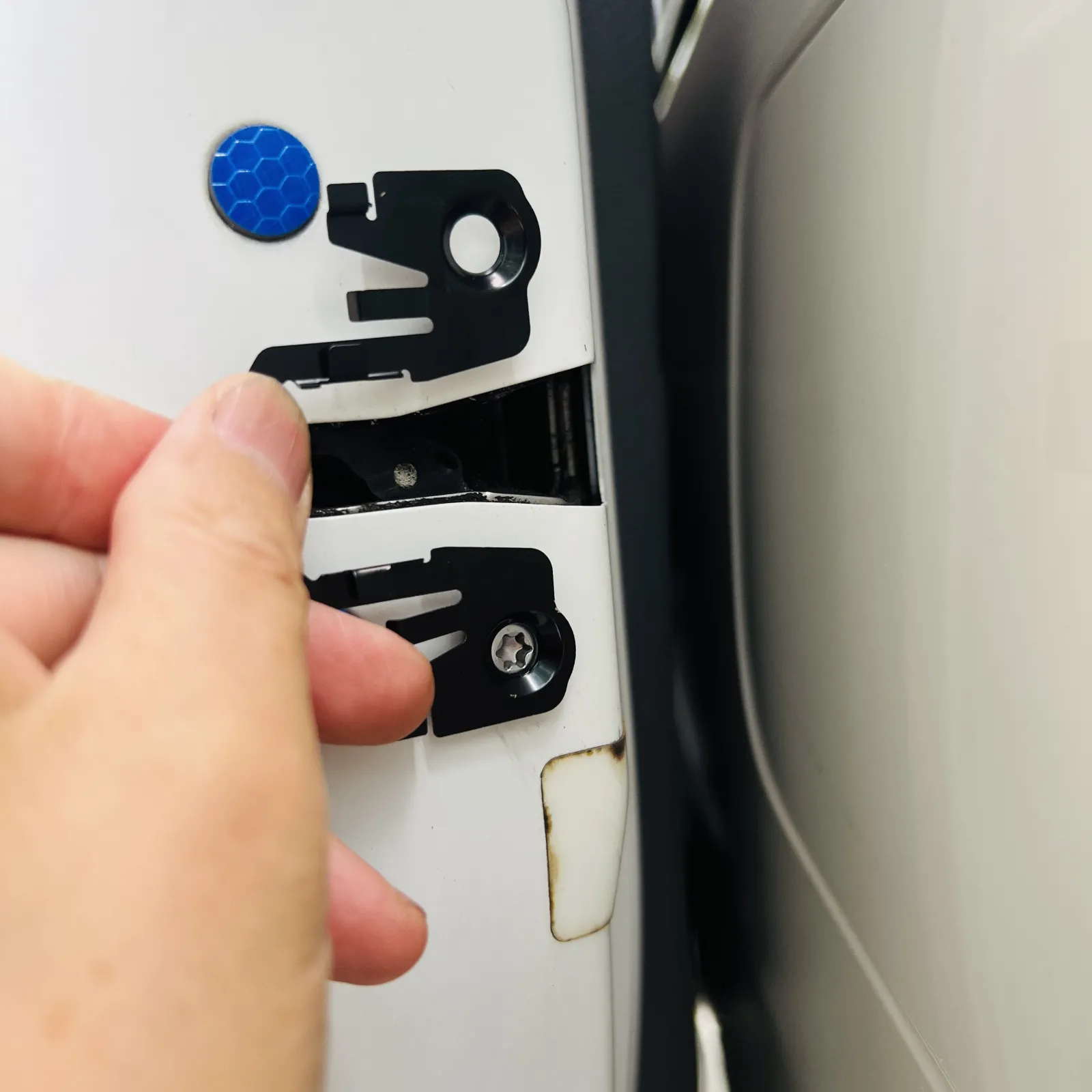 問題はストライカー側です。フロントドアと違って装着用のネジ穴形状が異なる為。本来2本のネジと共じめする部品が装着できません。