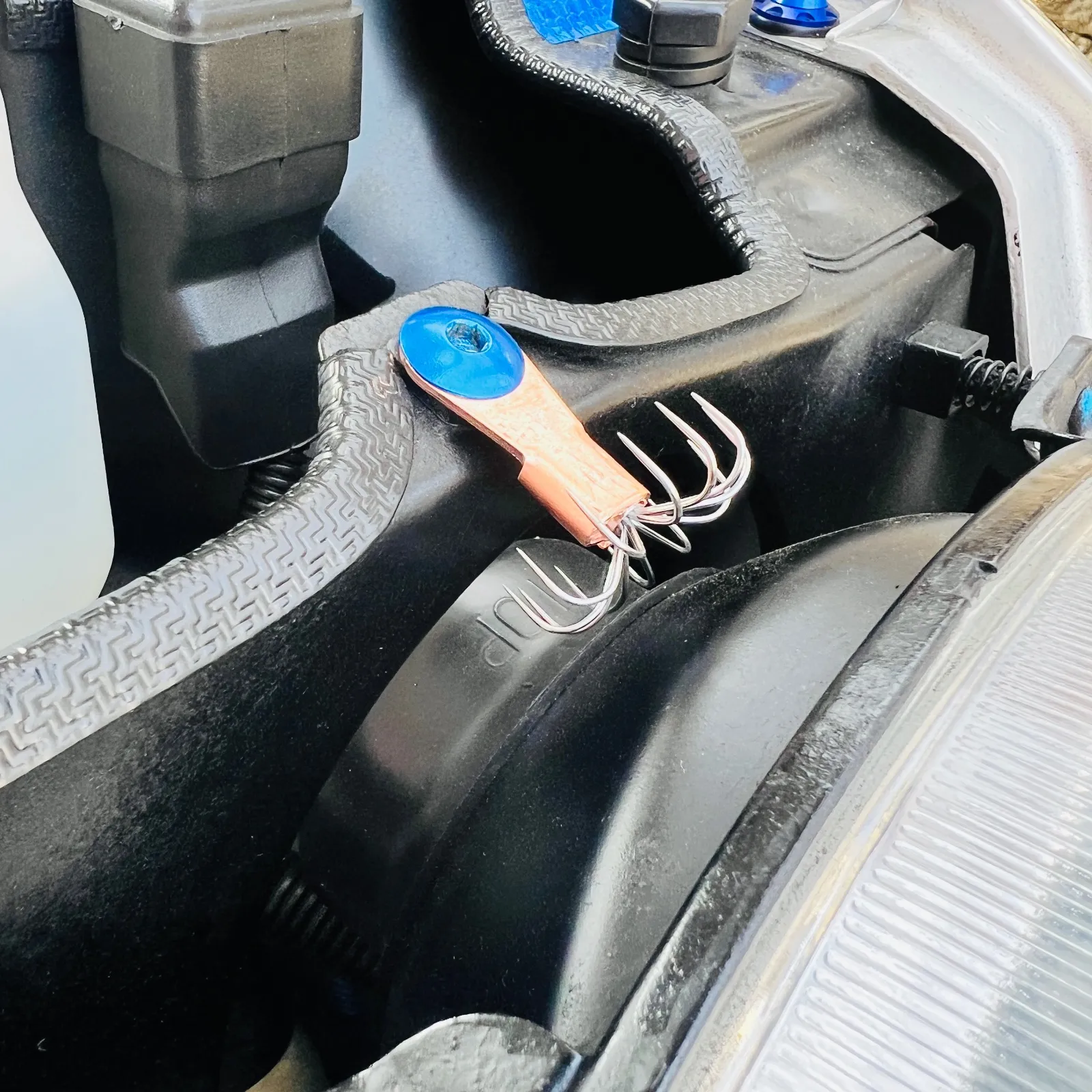 トヨタのアルミテープに始まった静電気の放電による車両特性の向上効果、大空を飛ぶ航空機も大昔より、空気との摩擦による静電気には悩まされてきました。現代では大型機、小型機に関わらず、放電策（スタティックディスチャージャー）と言う装置で静電気を空中へと放電しています。これは主に翼後端に付けられた鋭利な棒状の形状をしています。

理想的な放電策とは先端が鋭利であるほど放電しやすくなり、イオン生成量が増します。
さらに放電索は数が多いほど放電しやすくなりますが、欲張って密集させ過ぎると却って効率が落ちてしまうそうです。
多すぎると電界的に突出しなくなるとのこと。

コロナ放電とは電界的に突出している箇所(放電索)からの電子の吸引・放出ですが、放電索が密集していると隣の放電索の電界が干渉し、電界強度が弱まってしまうそうなんですね。
研究機関が調べたところによると、並行に並べた電極同士の間隔が4mm以下だと一部の電極がコロナ放電しなくなり、放電している電極も勢いが弱まりイオン量も減ってしまったそうです。
つまり、放電索同士の間隔は5mm以上は開けた方が効率が良いと言う事になります。

以上の研究結果より、車両に設置される理想的な放電策としての条件を考えると。
1 鋭い方が放電しやすい
2 放電索の間隔は5mm以上が良い
3 導電性が高い方がこまめに放電する
以上の条件を満たし、
車両整備時の作業者の為にただ鋭利な形状ではなく、安全性の確保をしつつ形状の美しさを持つ！

そして私が考えた理想的な放電策（スタティックディスチャージャー）とは！😆

イカ釣り針なのです😆😆

今回このイカ釣り針を純銅の端子でカシメて作成したものを『CYBER放電策（C.S.D : Cyber Static Discharger）』と命名しました。

これ良いですよ。車体に干渉せずしっかりと放電したい箇所に設置すれば、見た目はまあアレですが。確実な車両特性の向上に寄与します。