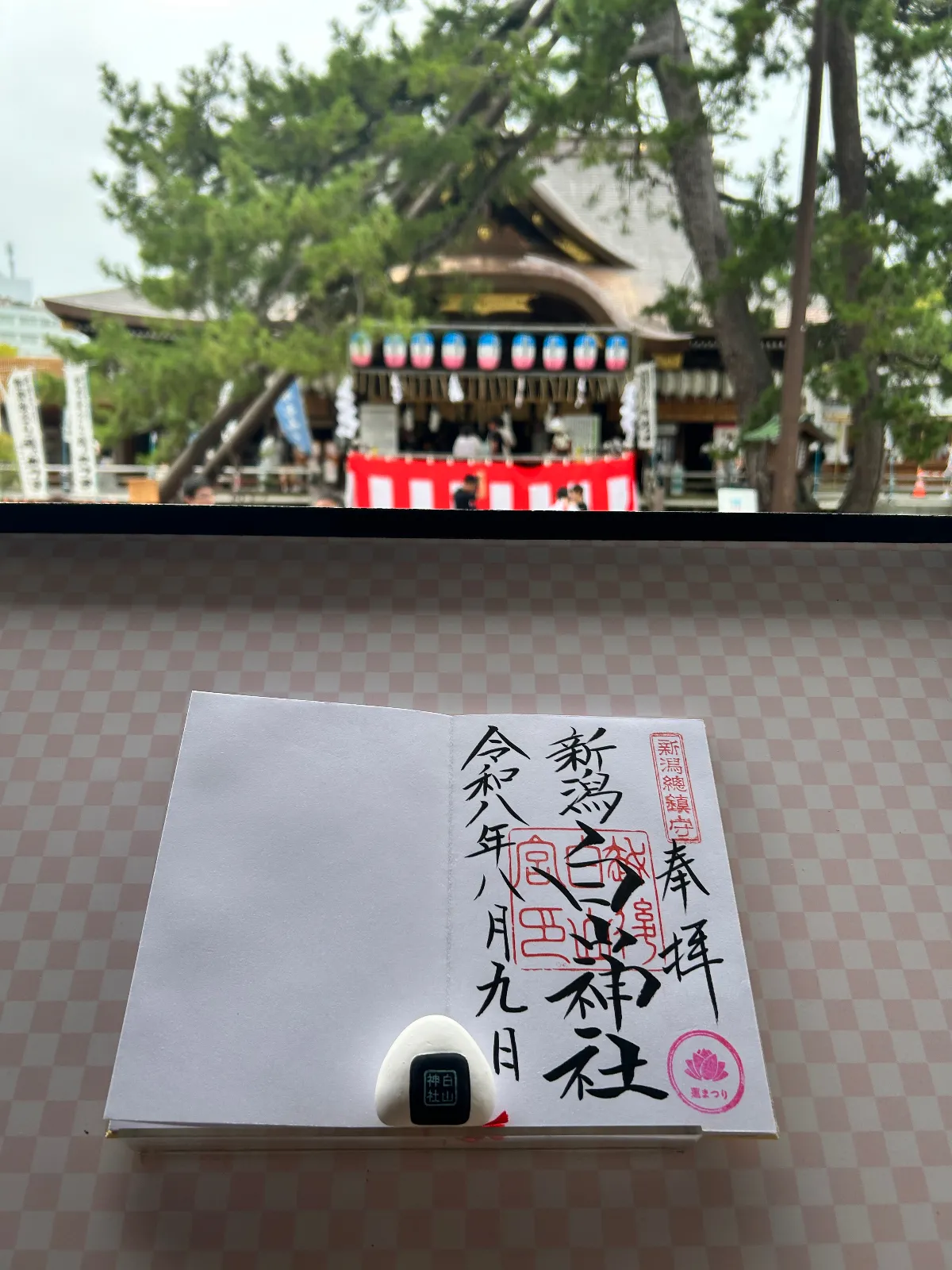新潟総鎮守の肩書を持つ白山神社。
今年 中3生で高校受験を控えた子を持つ我が家は学問の神様やパワースポットを巡ってることから今回の新潟もこちらの神社にご挨拶。

ちょうどお祭り真っただ中なようで、早めの参拝を…と促されつつも
しっかりご挨拶。
おみくじが「おにぎり」の形だったので、食いしんガールズたちは迷うことなくおみくじをひく。
そして、御朱印とともに記念写真。

ちゃんとフォトスポット台が用意されているのでした。